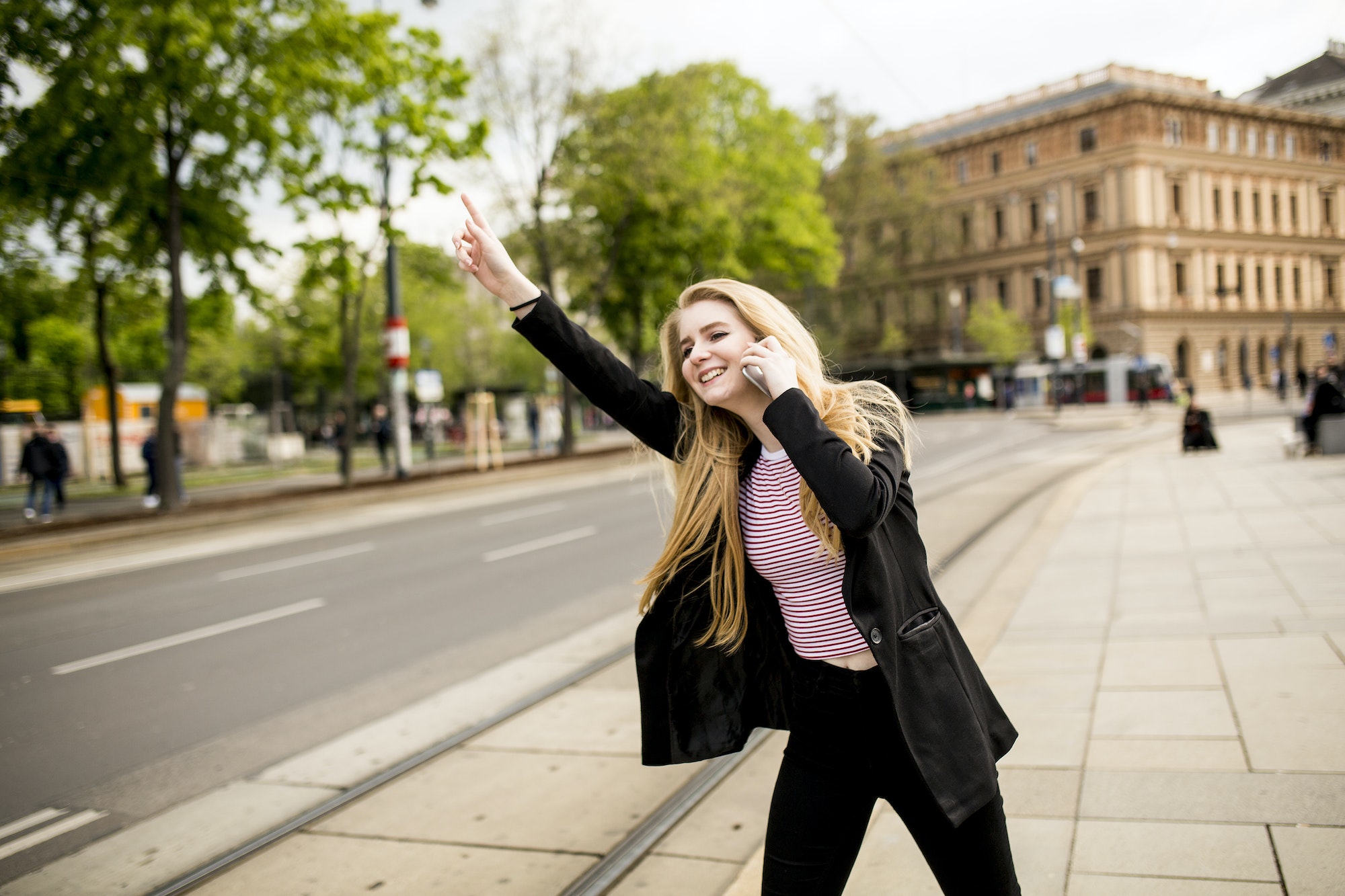 young-woman-hailing-a-taxi-on-the-street-in-the-city.jpg